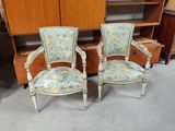 deux chaises et un meuble dans une pièce où se trouve une bibliothèque