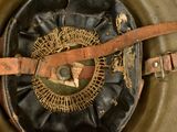 a close up of a military helmet with a leather belt