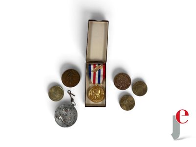 une petite boîte sur laquelle se trouvent des pièces de monnaie et une médaille