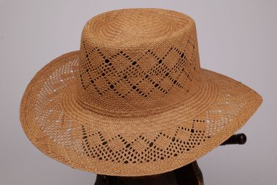 chapeau de paille marron muni d'une poignée noire, posé sur une tête de mannequin