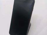 a black cell phone sitting on a stand on a table