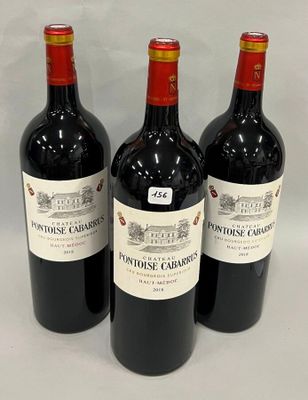 trois bouteilles de vin rouge sont alignées sur une surface blanche