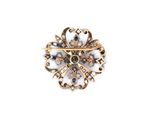 a close up of a gold broochle on a white background