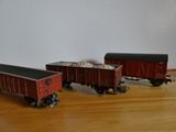 deux petits trains jouets posés l'un à côté de l'autre sur un plancher en bois