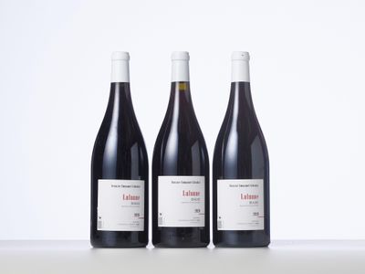 trois bouteilles de vin posées sur une table l'une à côté de l'autre