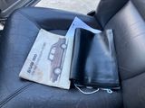 a car seat with a book on it and a wallet in the back seat