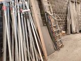 a lot of metal pipes leaning against a brick wall