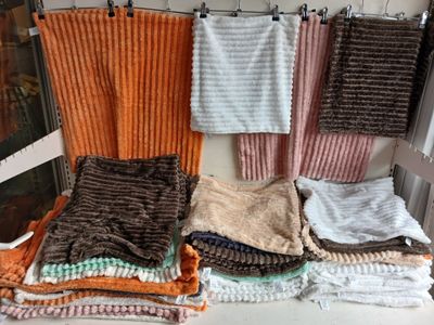 Plusieurs serviettes sont empilées sur une chaise devant une fenêtre.