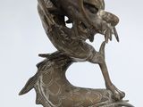 bronze statue of a dragon holding a fish in its mouth