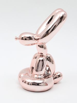 a pink balloon shaped like a rabbit sitting on top of a bowl