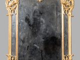 an ornate gold framed mirror with a black background