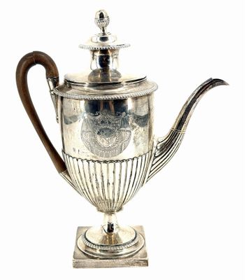 an antique silver teapot with a wooden handle on a stand