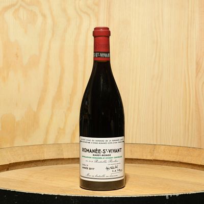a bottle of wine sitting on top of a barrel