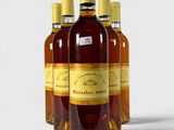 quatre bouteilles de vin sont alignées sur une surface blanche