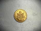 a close up of a gold coin on a white surface