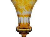 un vase en verre jaune orné d'un motif floral