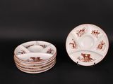 three brown and white plates and a bowl on a black surface
