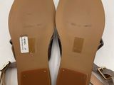 a pair of women ' s brown sandals on a white surface