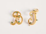 deux paires de boucles d'oreilles ornées de perles et de pierres vertes sur un fond blanc