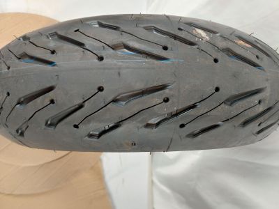 un gros plan d'un pneu de moto troué