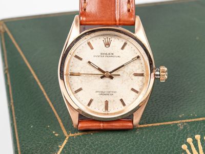 une photo montrant une montre posée sur un livre, sur une table
