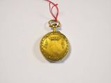 a small gold pocket watch hanging from a red string