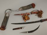 plusieurs types de couteaux et d'autres objets exposés sur une table