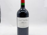 une bouteille de vin rouge posée à côté d'un verre de vin