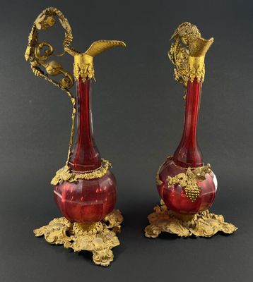 paire de vases anciens rouges et dorés sur un socle, sur fond noir