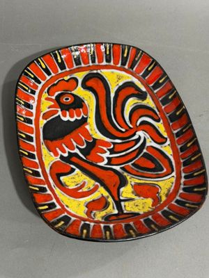 a red and yellow plate with a rooster on it