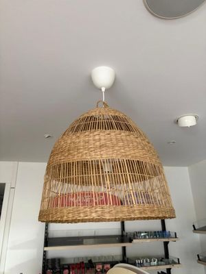 une lampe en osier suspendue au plafond dans une cuisine