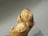 une petite statue représentant une femme assise sur une chaise