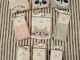 six paires de chaussettes ornées de têtes de pandas, posées sur une couverture rayée