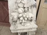 une statue représentant une chaise sur laquelle est posé un panier de fruits