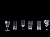 Plusieurs verres à vin vides sont alignés en rangée sur un fond noir