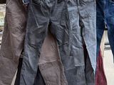 plusieurs paires de jeans suspendues à une corde à linge devant des cartons