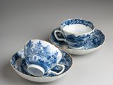 two blue and white cups and saucers on a table
