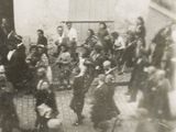 une photo en noir et blanc d'un groupe de personnes dans une cour