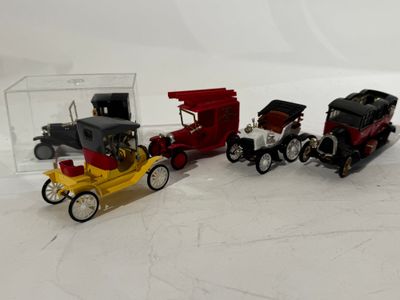 three toy cars sitting next to each other on a white surface