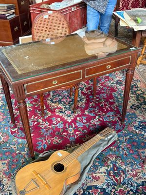 a woman standing next to a table with a guitar on it