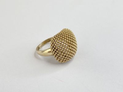 gros plan d'une bague en or sur une surface blanche