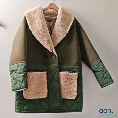 un manteau suspendu à un cintre accroché au mur