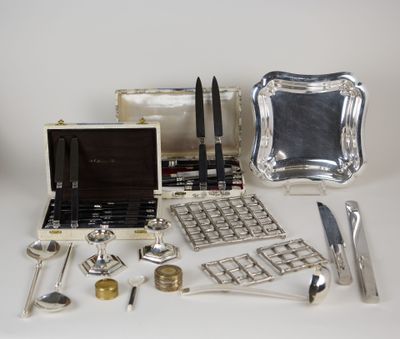 un plateau en argent sur lequel sont disposés des couverts et d'autres objets en argent