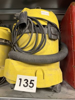 un aspirateur jaune et une valise rouge sur une étagère