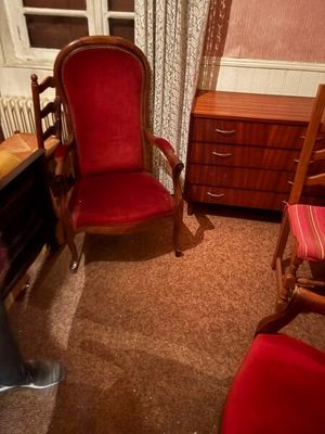 une chaise rouge et un bureau dans une petite pièce