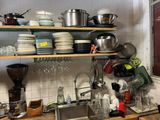 une cuisine où il y a beaucoup de vaisselle et de plats sur les étagères