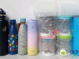 many different types of water bottles and containers on the table