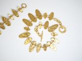 a close up of a bracelet with gold charms on a white surface