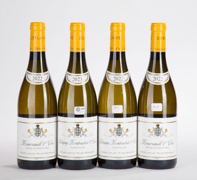 quatre bouteilles de vin sont alignées sur une surface blanche