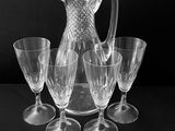 photographie en noir et blanc représentant une carafe et quatre verres à vin